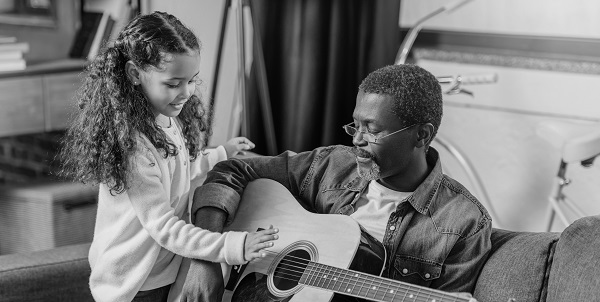 grandfather and granddaughter practicing guitar in their own home