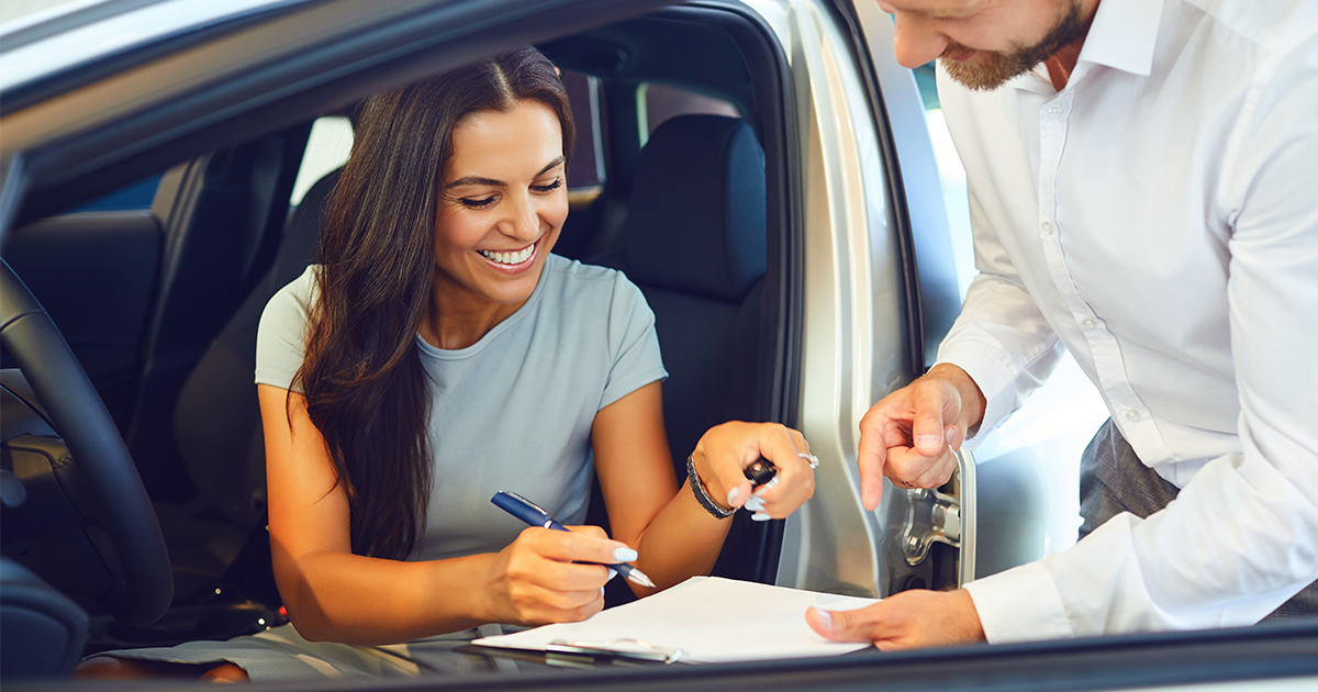 person signing paperwork for car