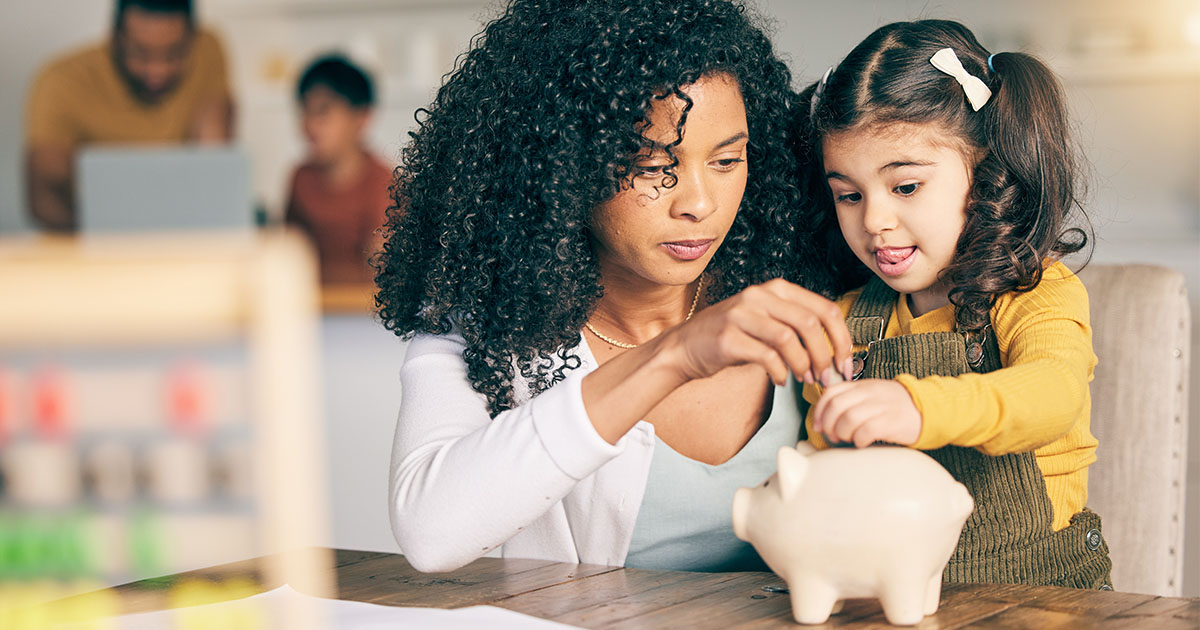 parent and child putting coin in piggy bank