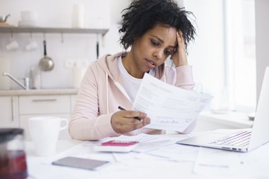 woman at desk looking at bills worried