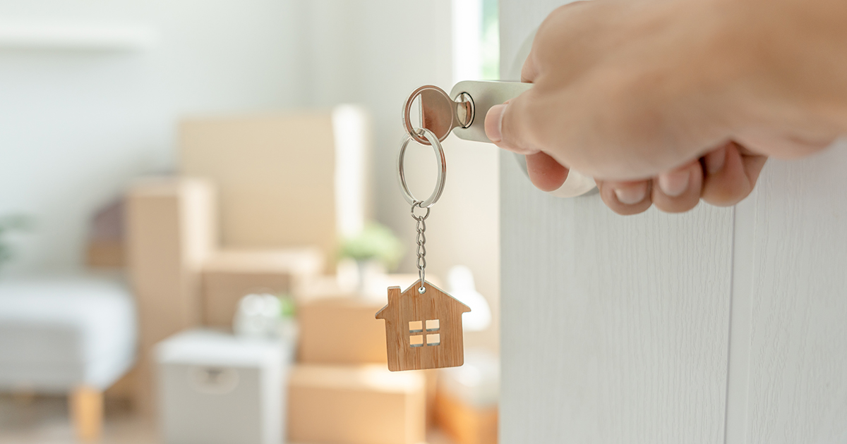 Person opening door with home figure keychain