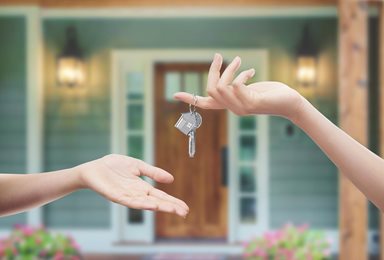 home buyer with their hand out getting the key to their new home