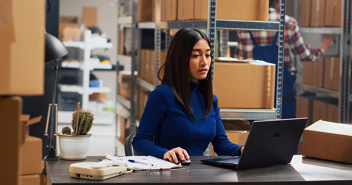 woman at laptop in warehouse